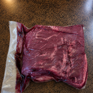 Vacuum-sealed raw beef steak on countertop