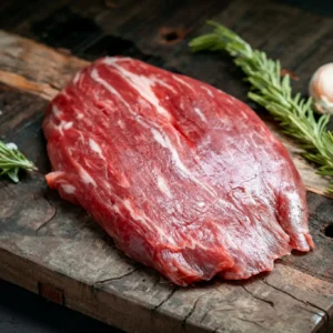 Raw flank steak with rosemary and garlic