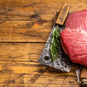 Raw beef roast with cleaver and rosemary