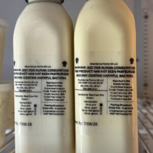Two labeled raw milk bottles in fridge
