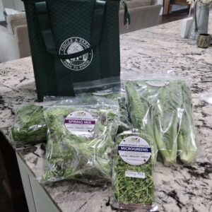Packaged lettuce and microgreens on marble counter