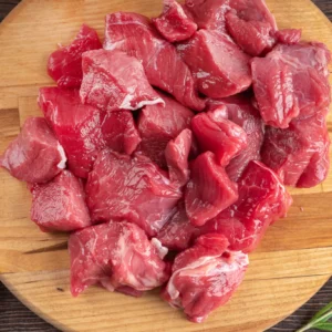 Raw diced beef on wooden cutting board
