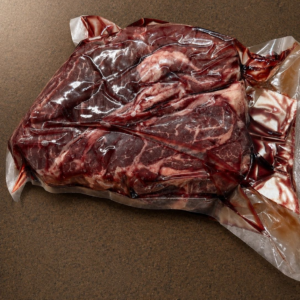 Sealed meat package on brown surface