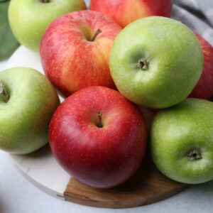 Red and green apples on white plate