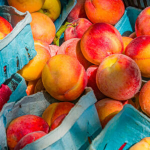 Fresh ripe peaches in blue baskets